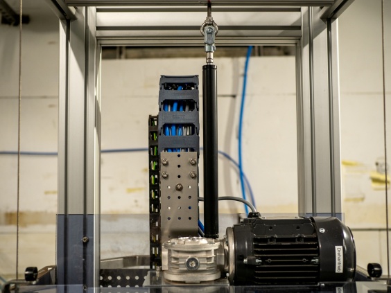 Die Verschraubereinheit l&auml;sst sich dank der Gaszugfeder (Mitte) f&uuml;r das Bedienpersonal ohne viel Kraftaufwand heben und senken, TUBUS-Strukturd&auml;mpfer (links und rechts unten) fungieren als Anschlagd&auml;mpfer f&uuml;r die Schutzhaube.